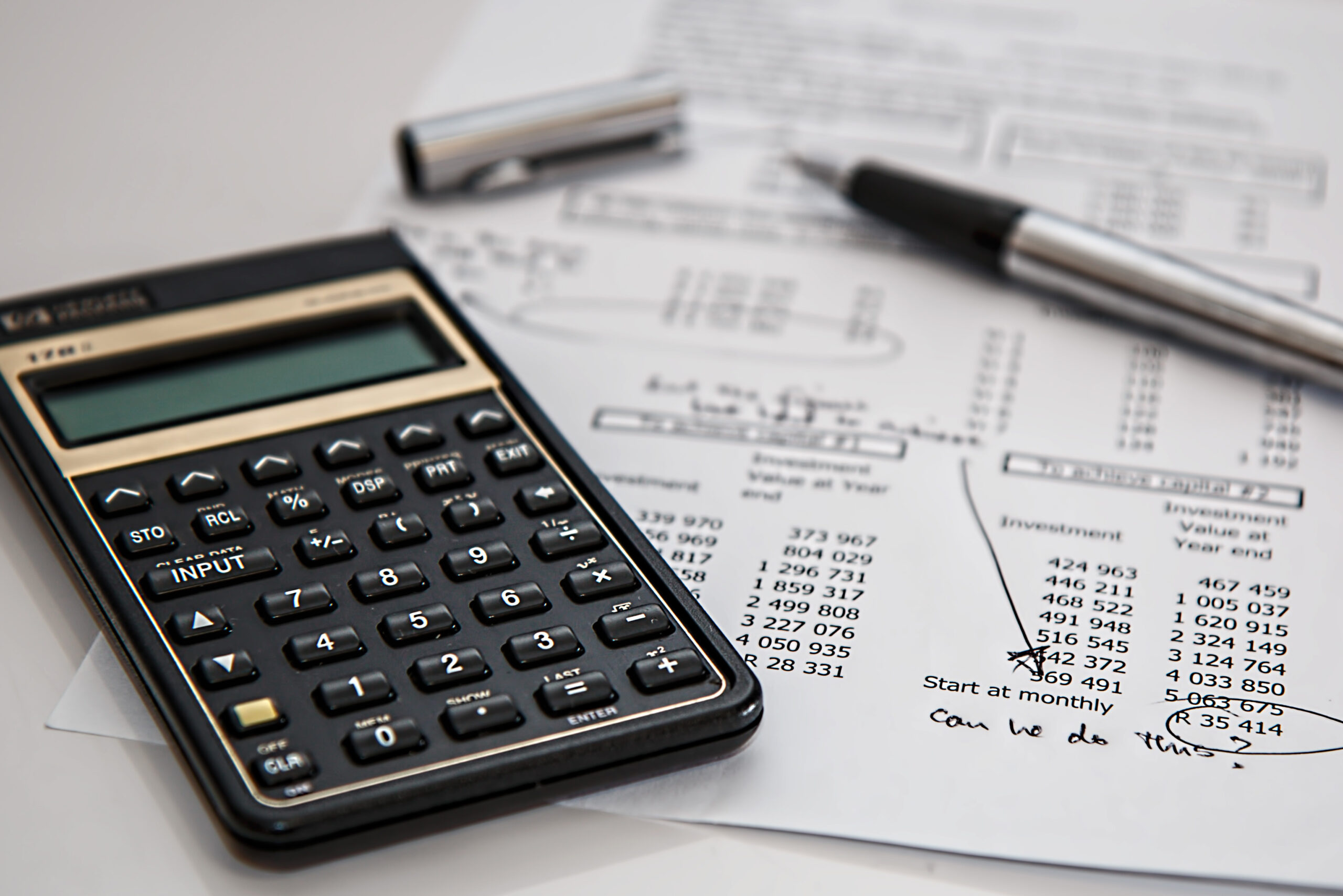 calculator and pen on sheet of paper