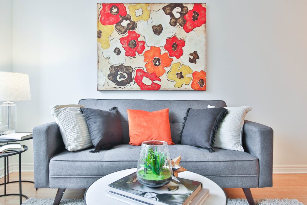 couch and coffee table with flower painting above couch