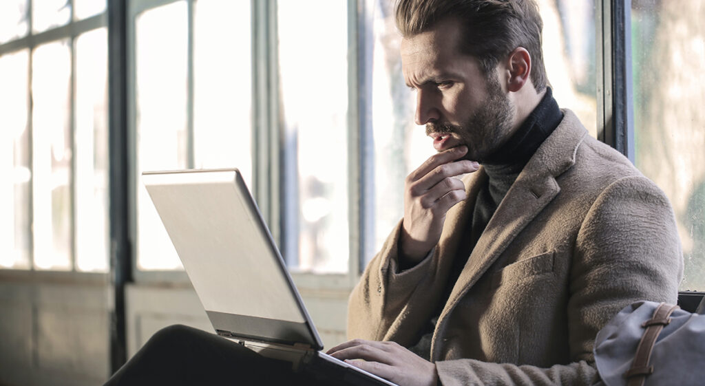 man looking questionably at laptop