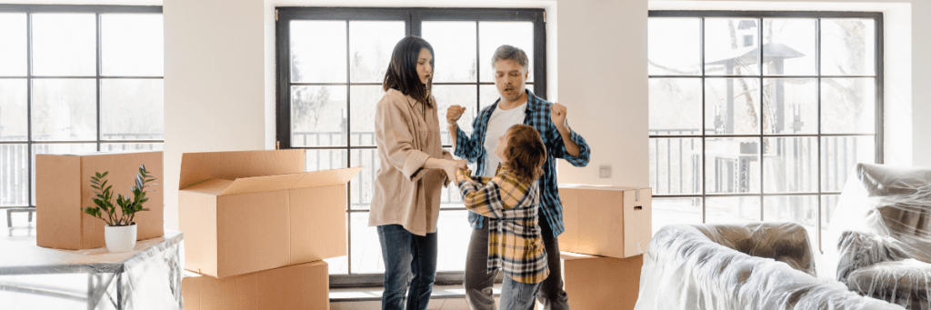 family dancing and celebrating in living room while unpacking